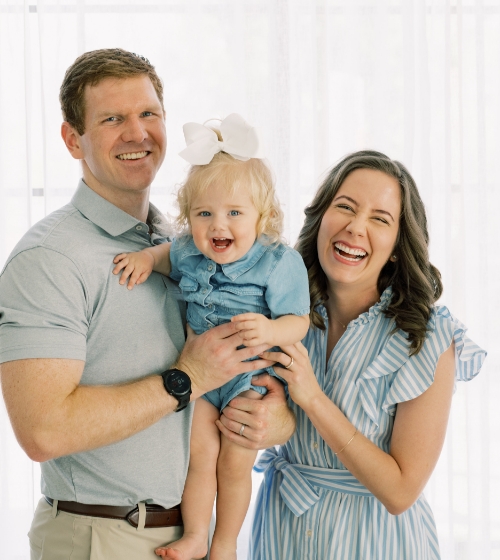 Doctor Hanson smiling with her husband and their baby