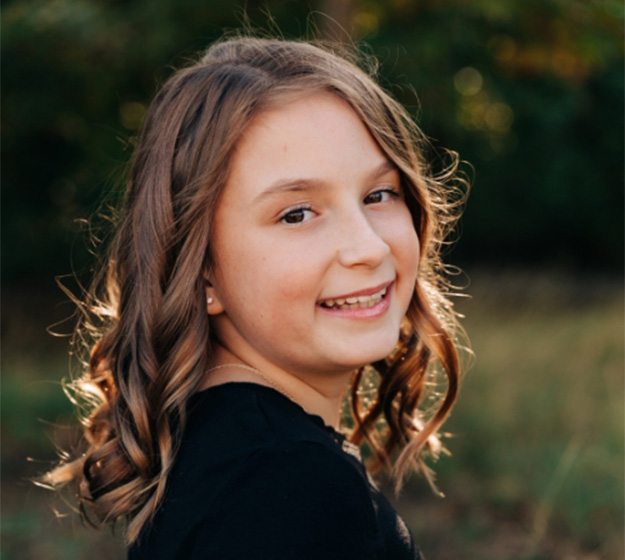 Young girl with braces smiling outdoors