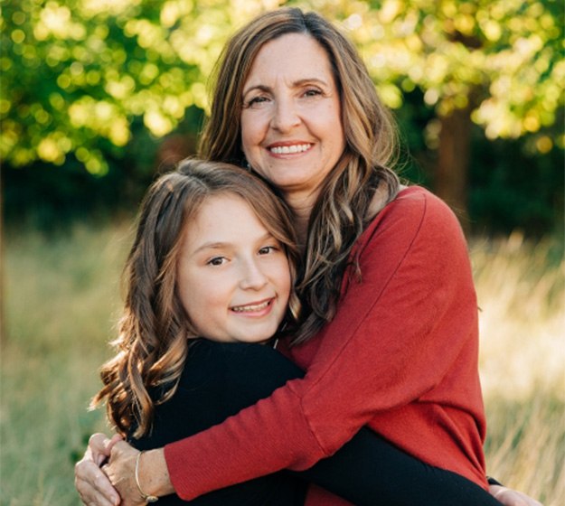 Mother hugging her daughter outdoors