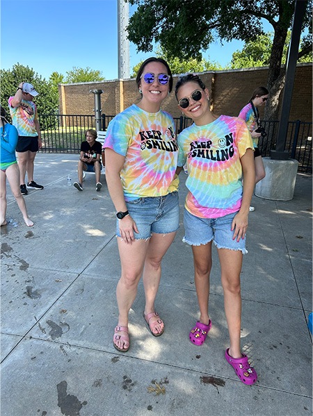 Two orthodontic team members in matching tie dye tee shirts