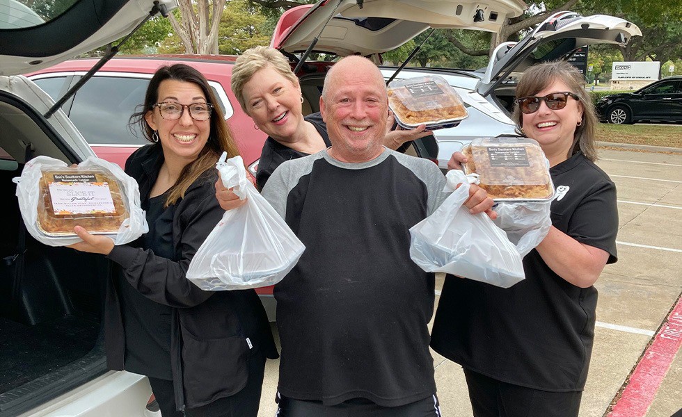 Team members holding several store bought desserts