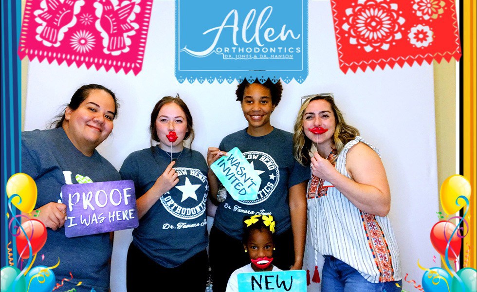 Several team members in a photo booth holding props