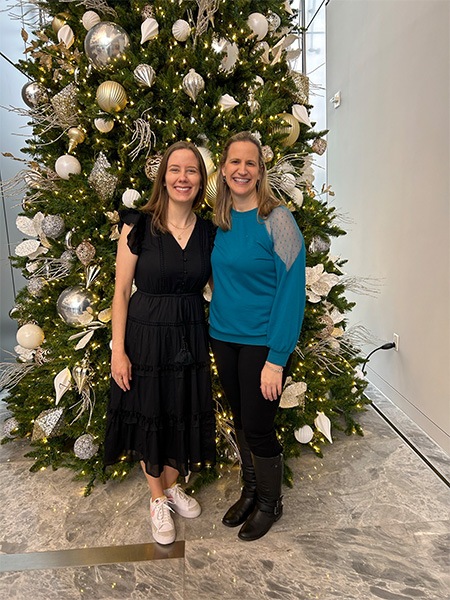 Doctor Hanson smiling with a woman in front of a Christmas tree