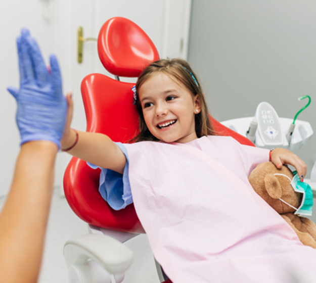 Young girl high-fiving a member of her orthodontic team
