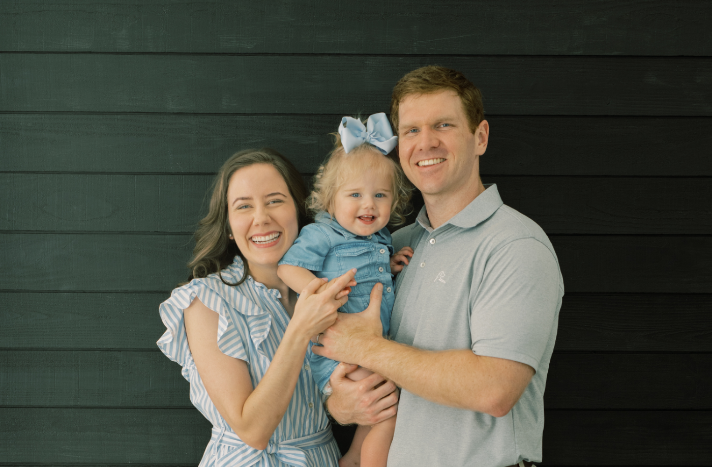 Allen orthodontist Doctor Megan Hanson smiling with her husband and child