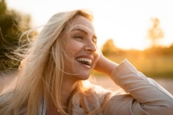 Blonde woman smiling outdoors on a sunny day