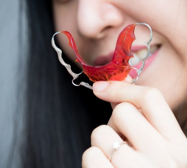 Close up of a person holding a retainer