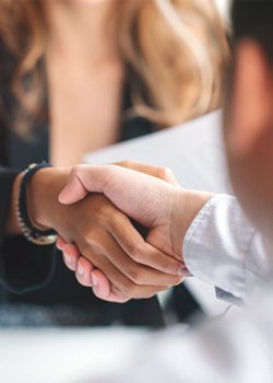 Two people shaking hands in a professional setting