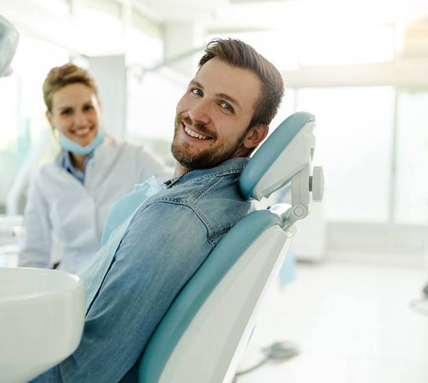 Happy dental patient smiling in treatment chair