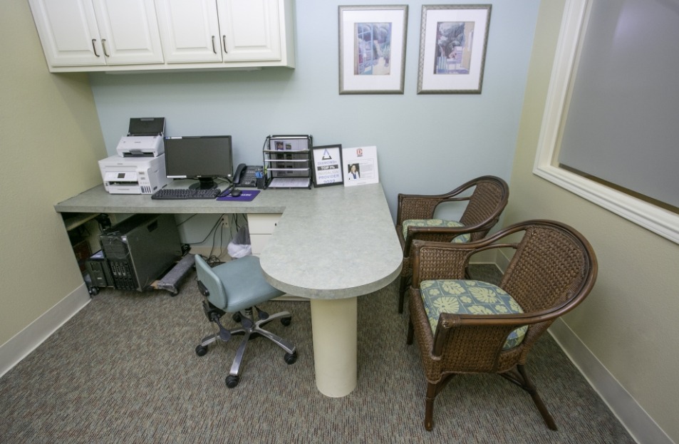 Small gray desk with computer in consultation room