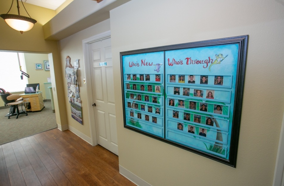 Photo collage on wall of patients before and after orthodontic treatment