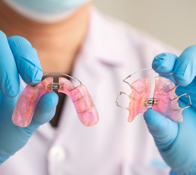 Orthodontist holding two retainers