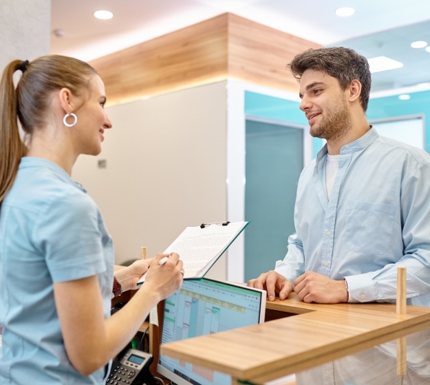 Man talking to front desk receptionist of emergency orthodontist in Allen