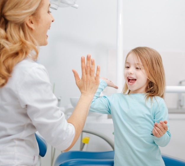 Young girl giving a high five to an orthodontic team member